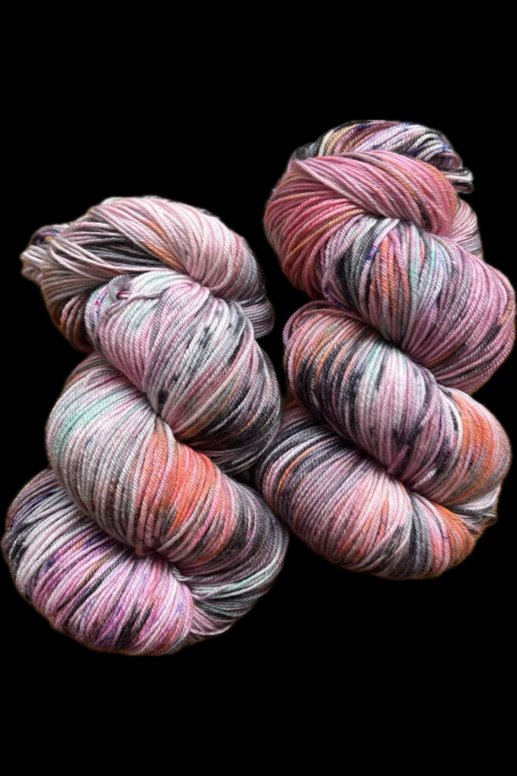 Two twisted skeins of variegated yarn Feral Little Jimothy yarn, pink, purple, peach, and gray tones, displayed against a solid black background. Hand dyed in Minneapolis by Painted Skein.