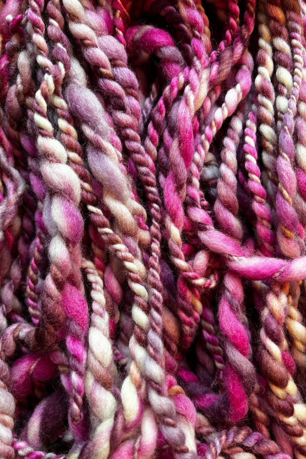 Hand dyed, hand spun in Minneapolis, Orchid Whirl 2 ply art yarn in shades of magenta, purple, lavender and cream.