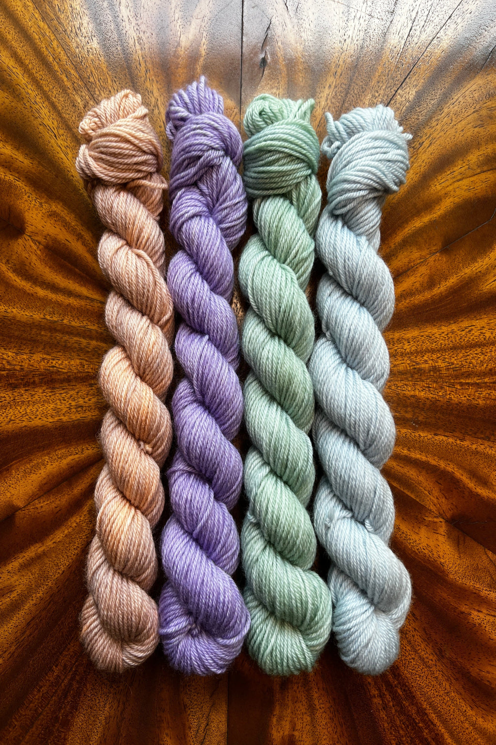 Set of four hand dyed 20-gram mini skeins in tonal hand-dyed yarn colorways designed to coordinate with The Painted Skein’s Monet Sunrise Masterpiece Collection. 