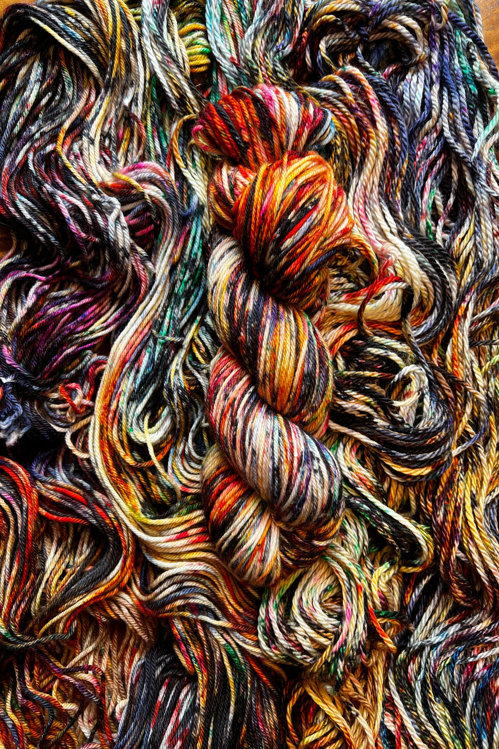 Twisted skein of Lady with Fan hand dyed in Minneapolis on top of flat skein of same yarn from Painted Skein, Masterpiece Collection.