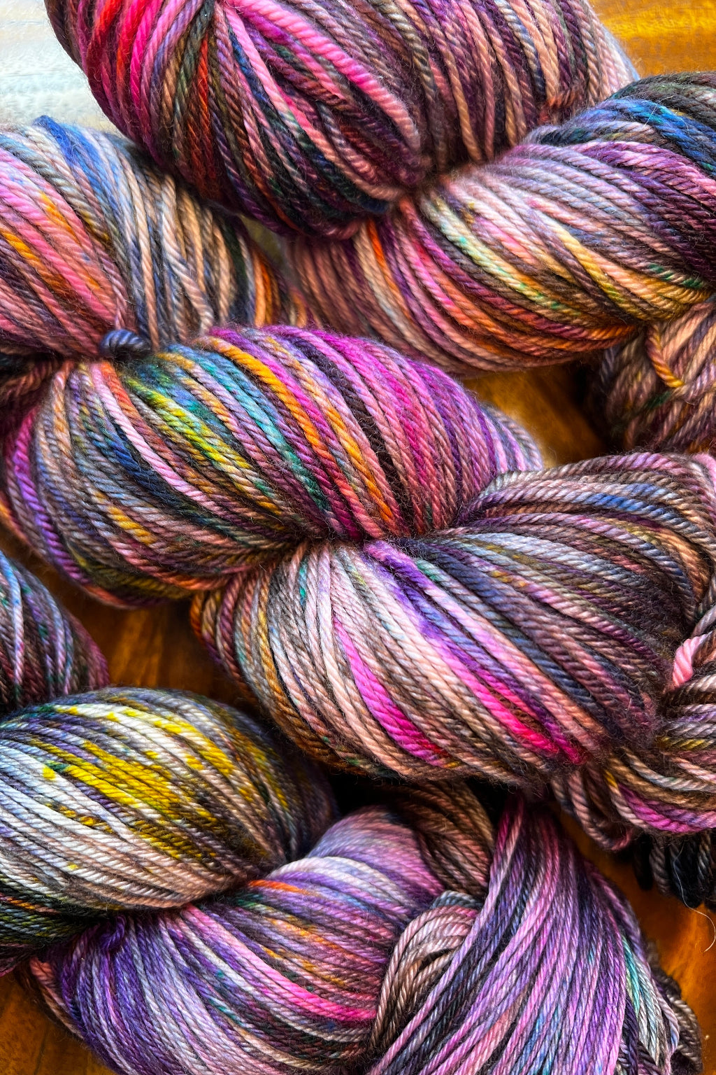 3 skeins of Wild Fig, painterly air brushed and speckled merino yarn. Hand dyed in shades of brown, hot pink, purple, lavender, golden orange, green and blue.