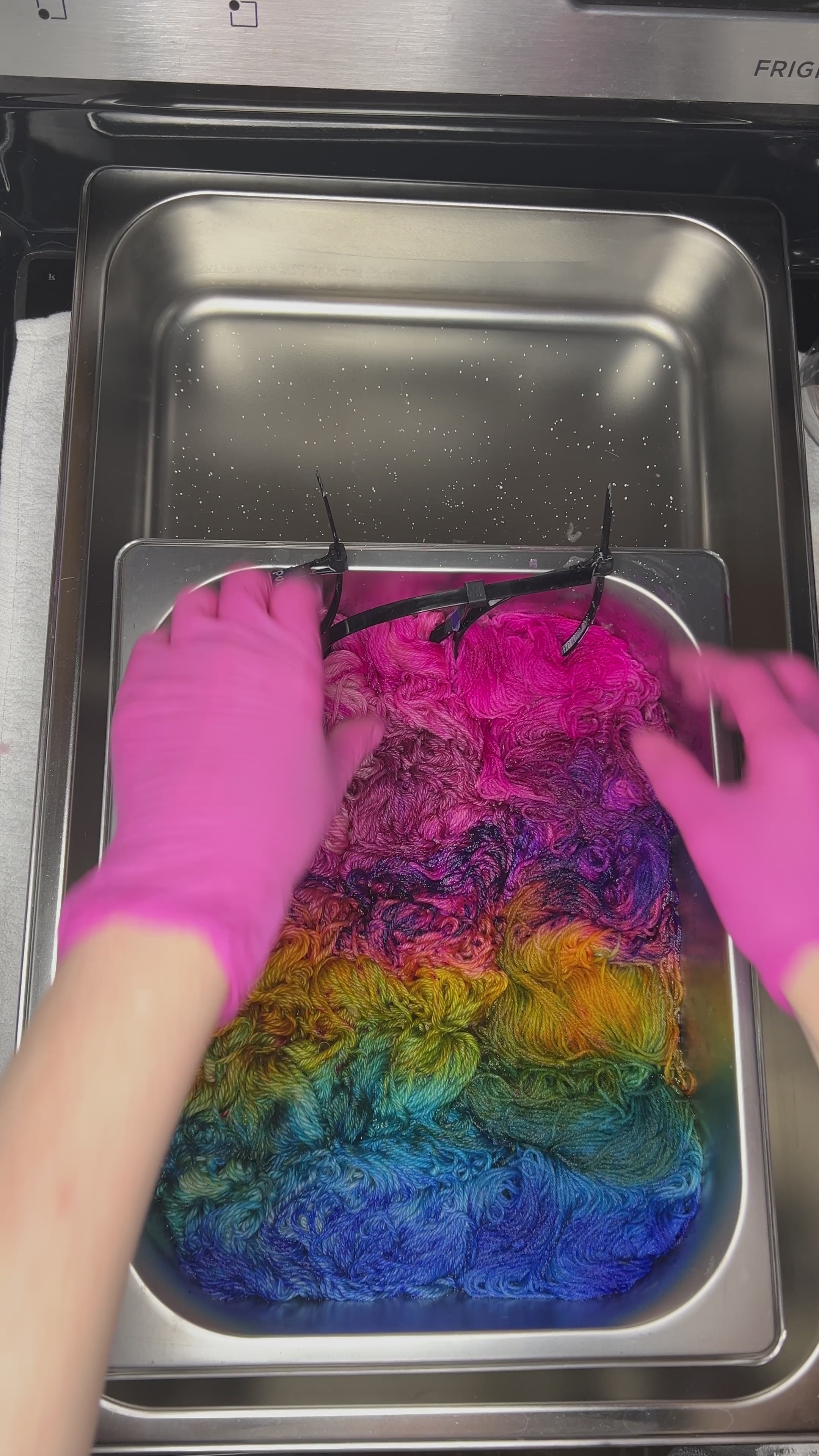 Video of wet skeins of bright pink, purple, blue and golden merino yarn, hand dyed in Minneapolis, by Painted Skein in Birch Rainbow colorway.