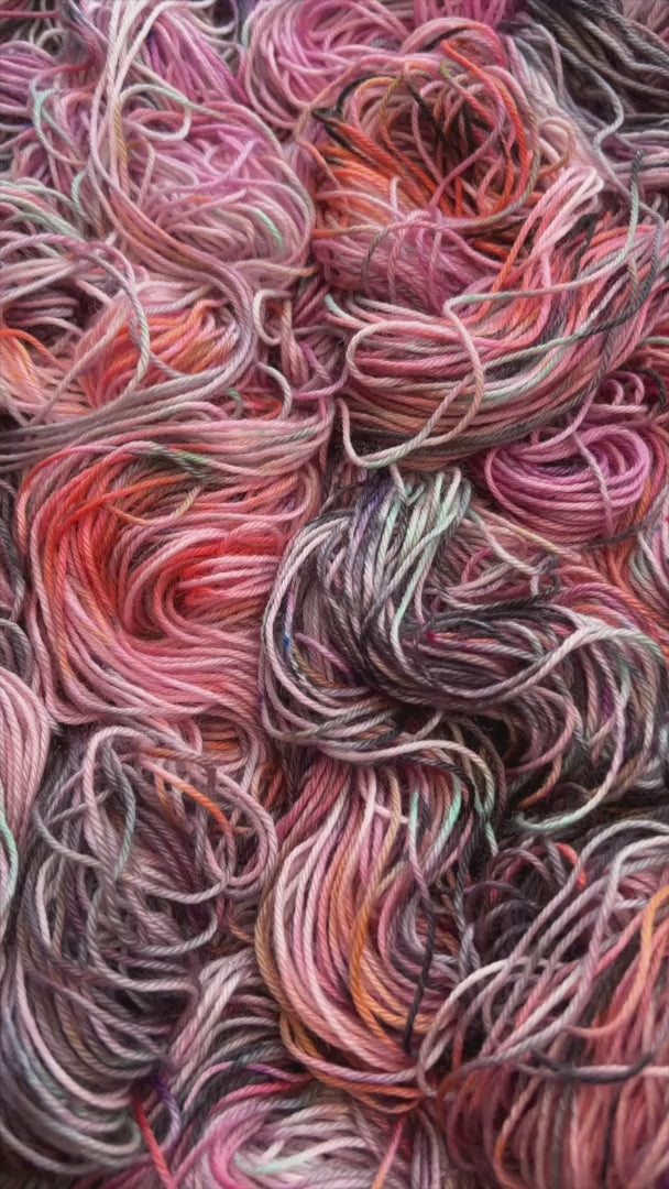 Video clip of Feral Little Jimothy colorway pink, peach, lavender, grey and black. Hand dyed in Minneapolis by Painted Skein.