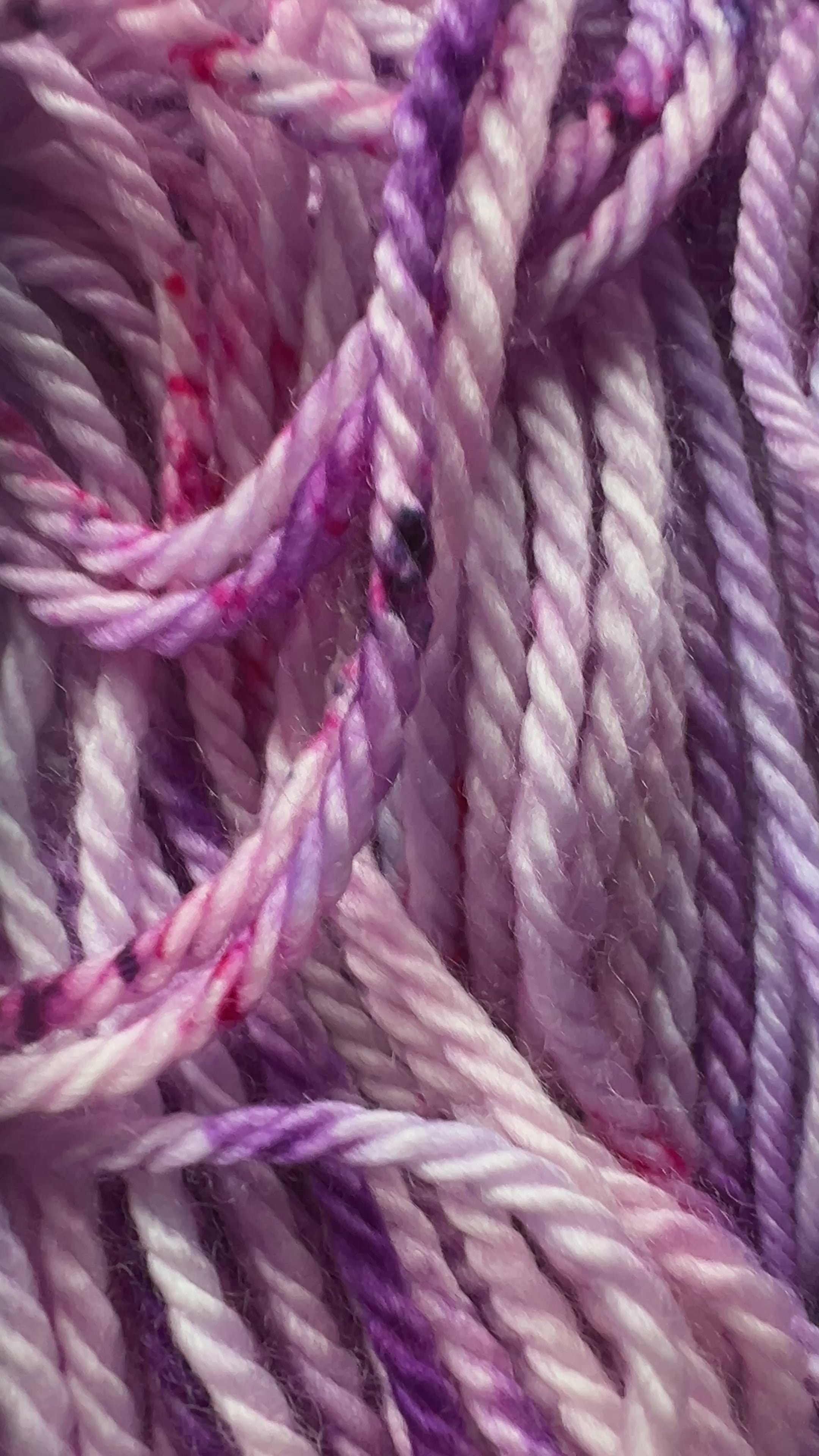 Soft lavender forms the hand-dyed yarn base, blooming into rich magenta and deep purple in a palette that feels both romantic and bold. 