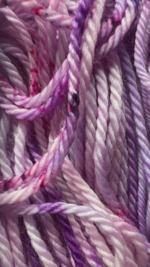 Soft lavender forms the hand-dyed yarn base, blooming into rich magenta and deep purple in a palette that feels both romantic and bold. 