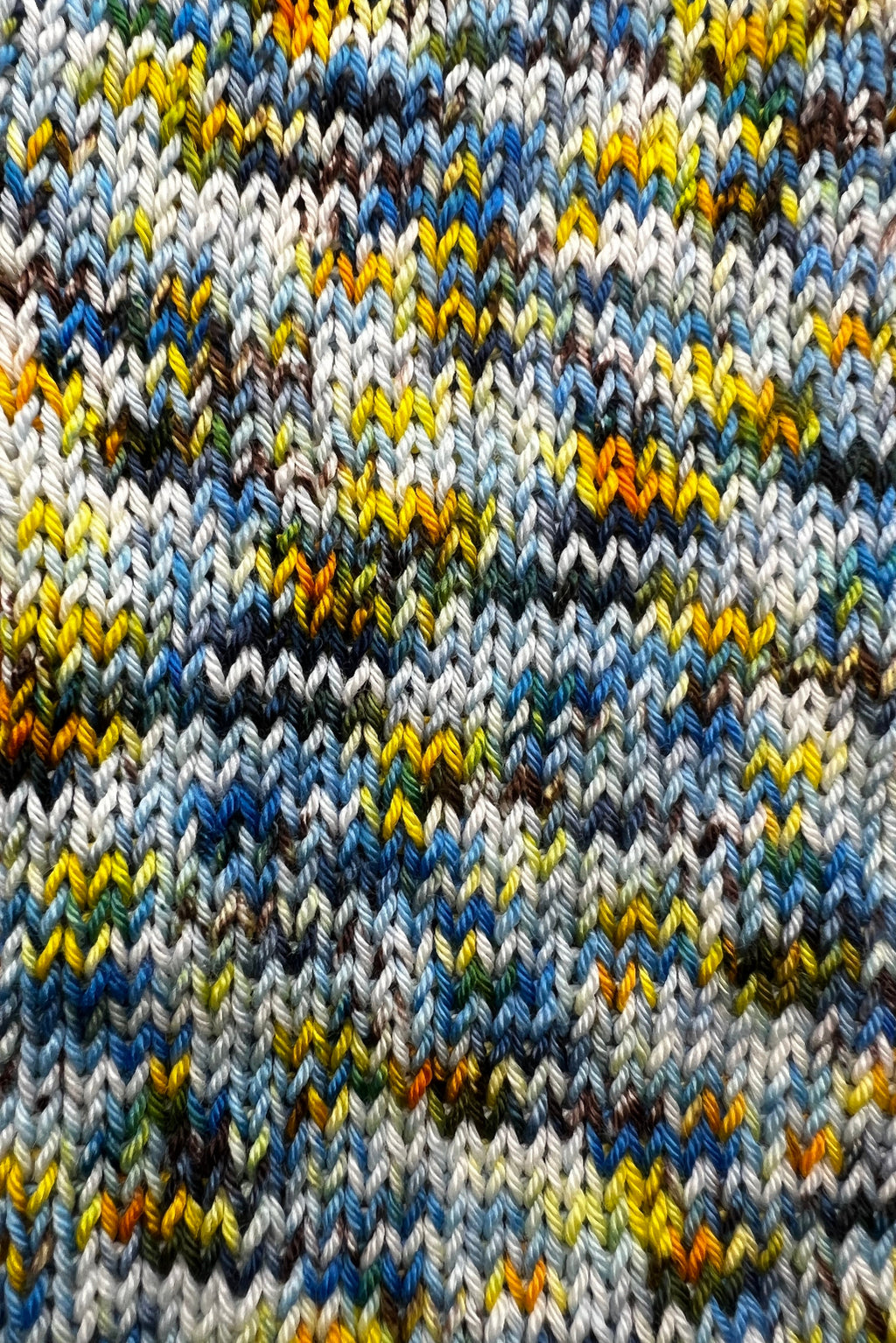 Close-up of a knitted fabric with multicolor pattern sample of hand dyed Starry Night yarn.